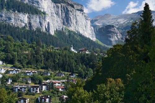 Free Picturesque village nestled in the Swiss Alps with beautiful mountain backdrop. Stock Photo