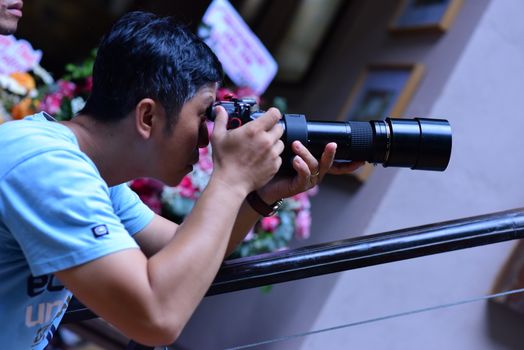 A photographer focuses on capturing moments with a telephoto lens, demonstrating professional photography skills.
