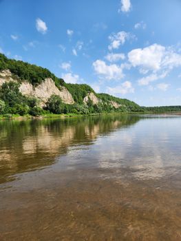 Beautiful river scene with limestone cliffs and clear blue sky, perfect for nature lovers.