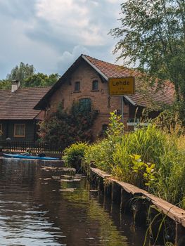 Charming view of a canal in Lehde, Germany, featuring rustic homes and lush greenery.