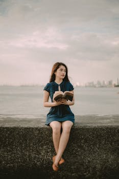 年轻女子在马尼拉湾海滨读书，享受宁静的日落