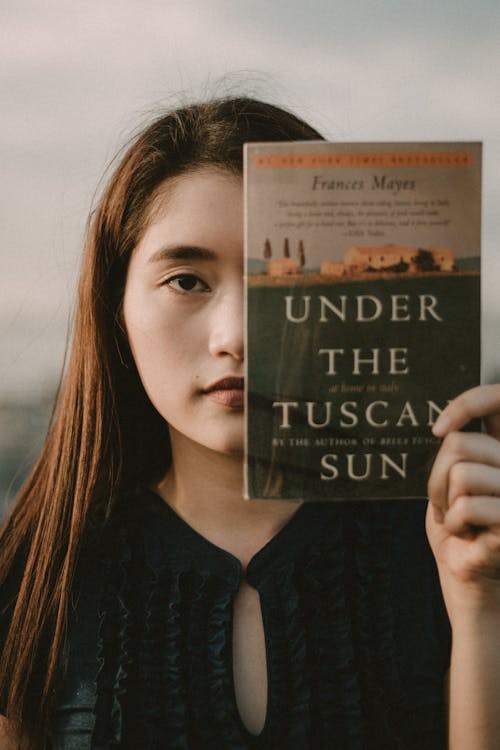 Женщина, держащаяся под книгой тосканского солнца