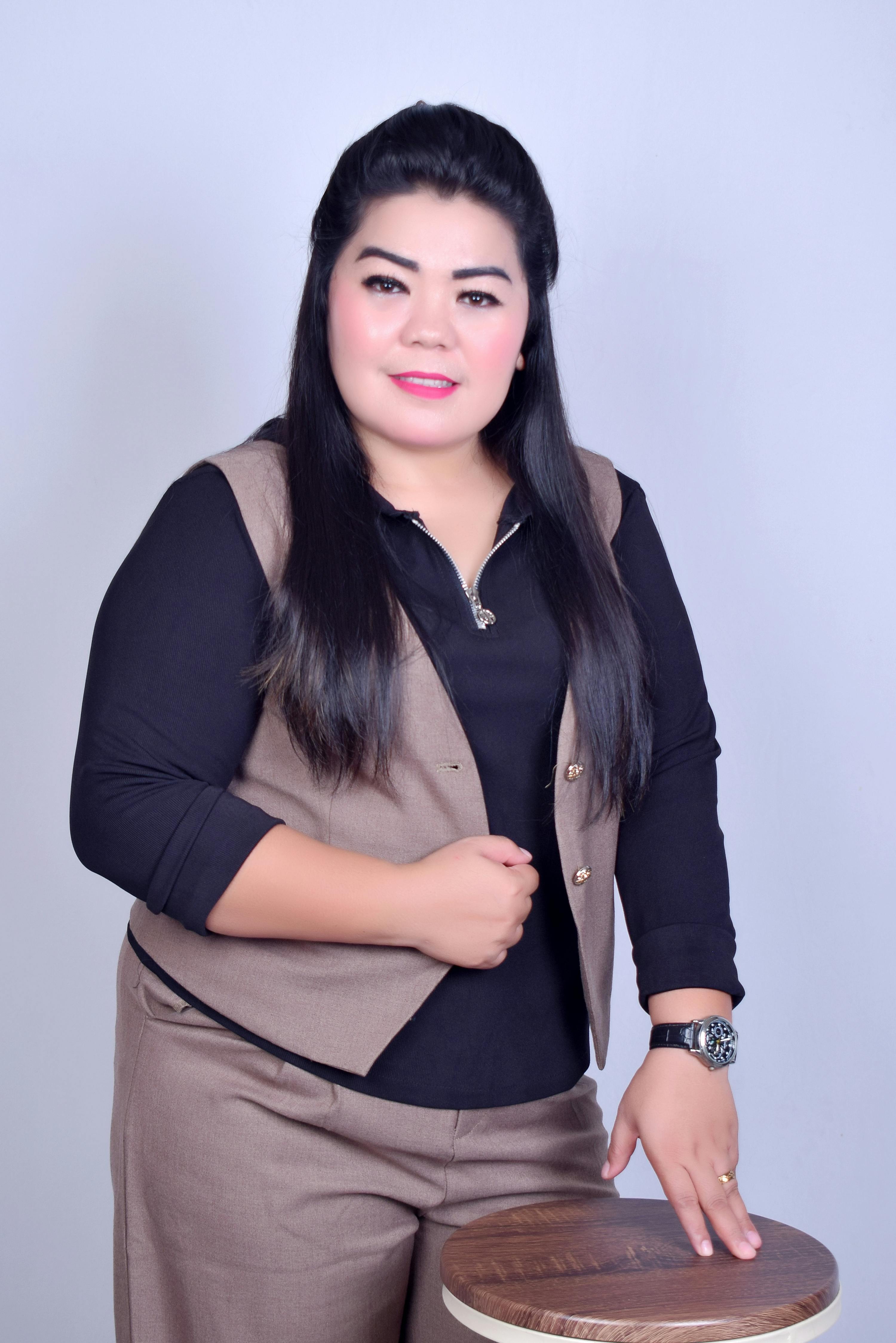 Woman in professional attire posing confidently indoors. Ideal for business or corporate themes.