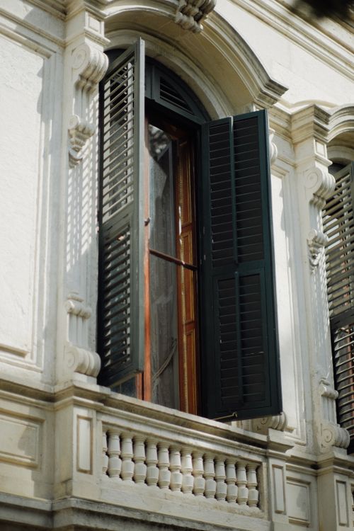 Free A classic architectural window with partially open shutters on a historic building facade. Stock Photo