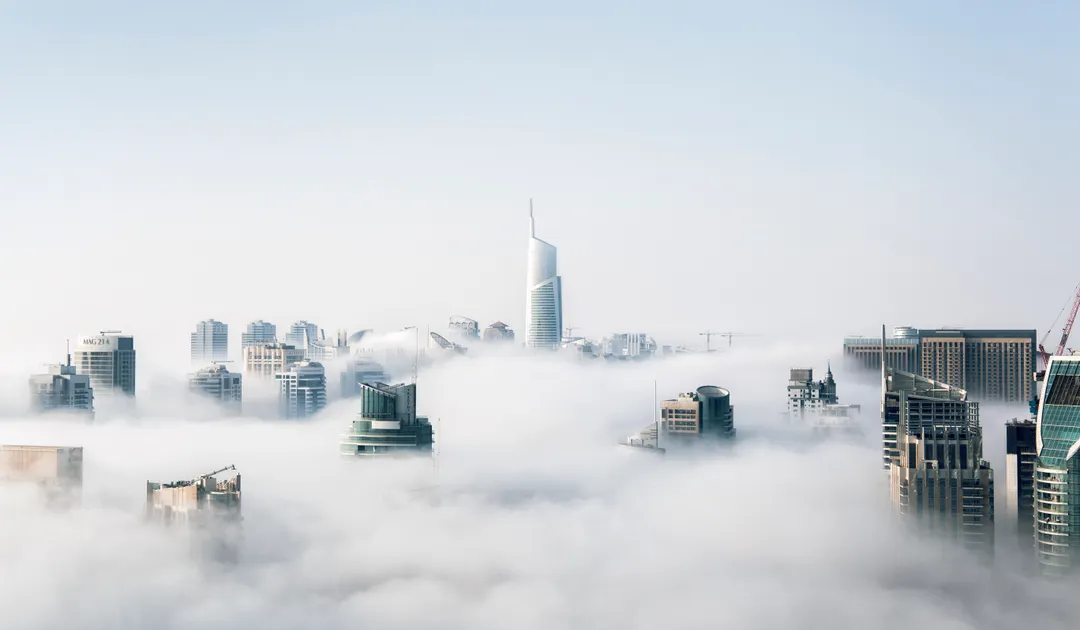 Dubai Marina towers rising above low cloud, where UK and European businesses relocate for a 9% corporate tax