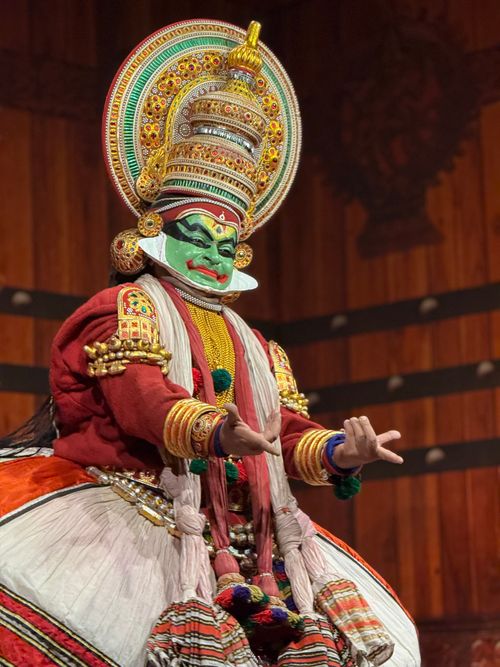 Free Kathakali dancer in vivid traditional attire performing on stage. Stock Photo