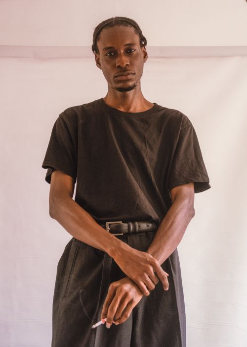 Free A man in casual attire poses confidently in a minimalist indoor setting. Stock Photo