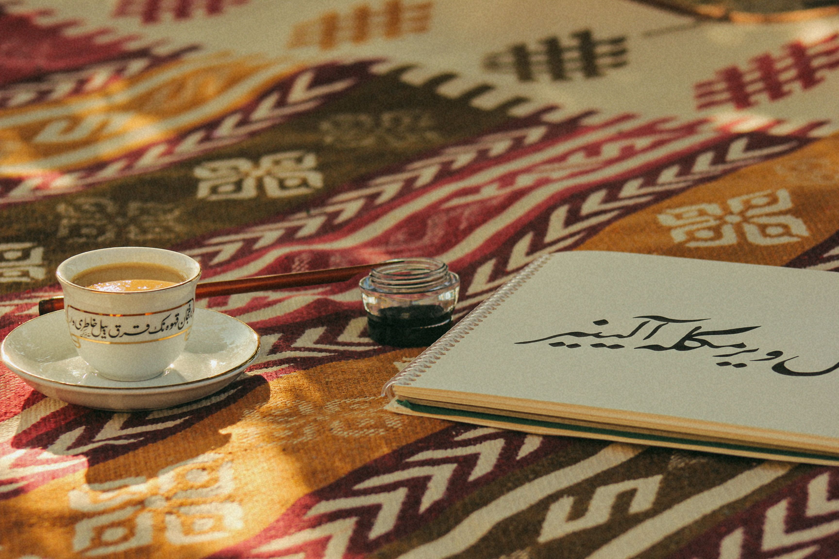 Handgeschriebene arabische Wortkarte neben einem Glas Minztee auf einem Cafétisch in Luxor