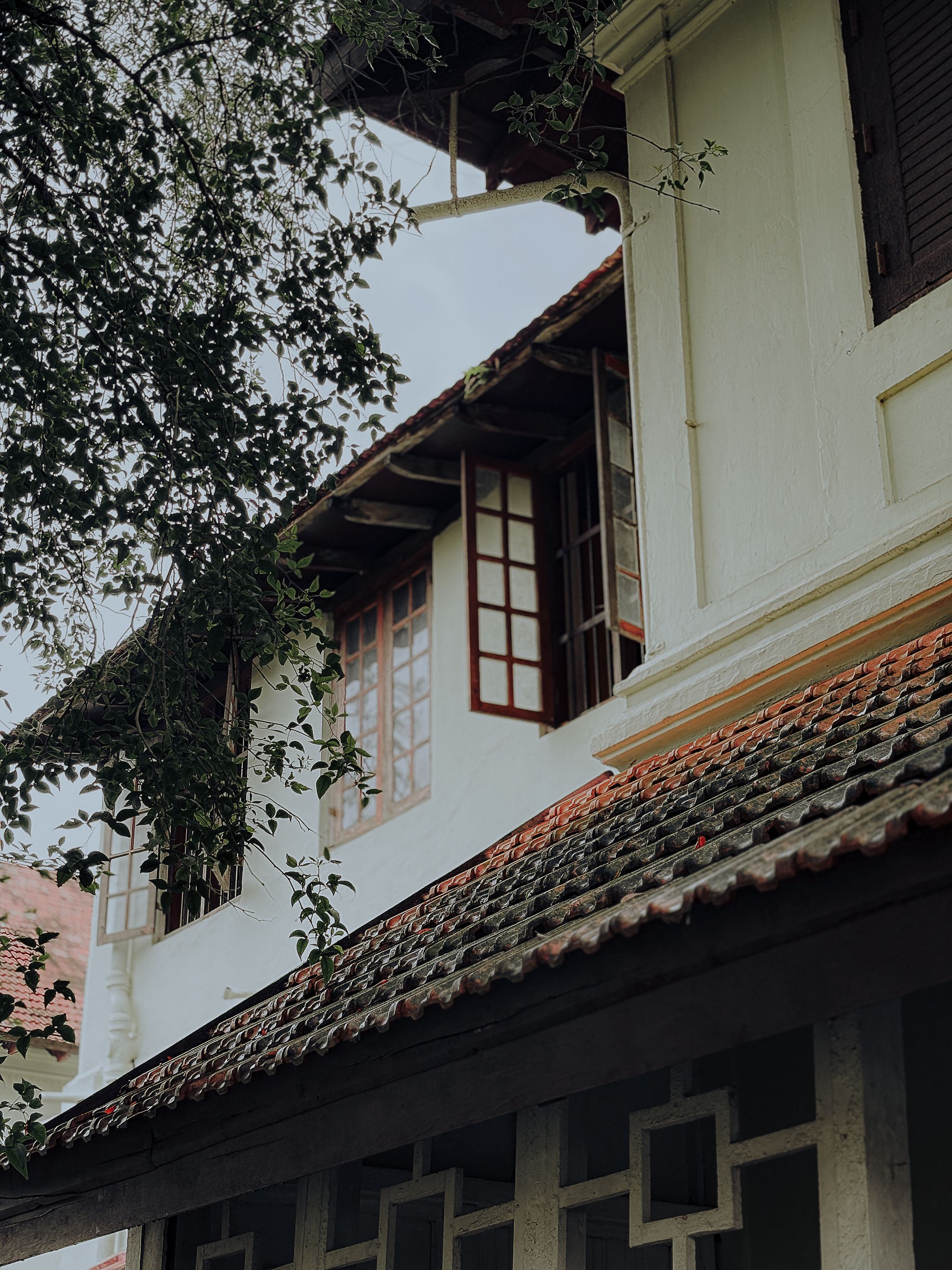 White-walled traditional house with timber windows under a tiled roof eave