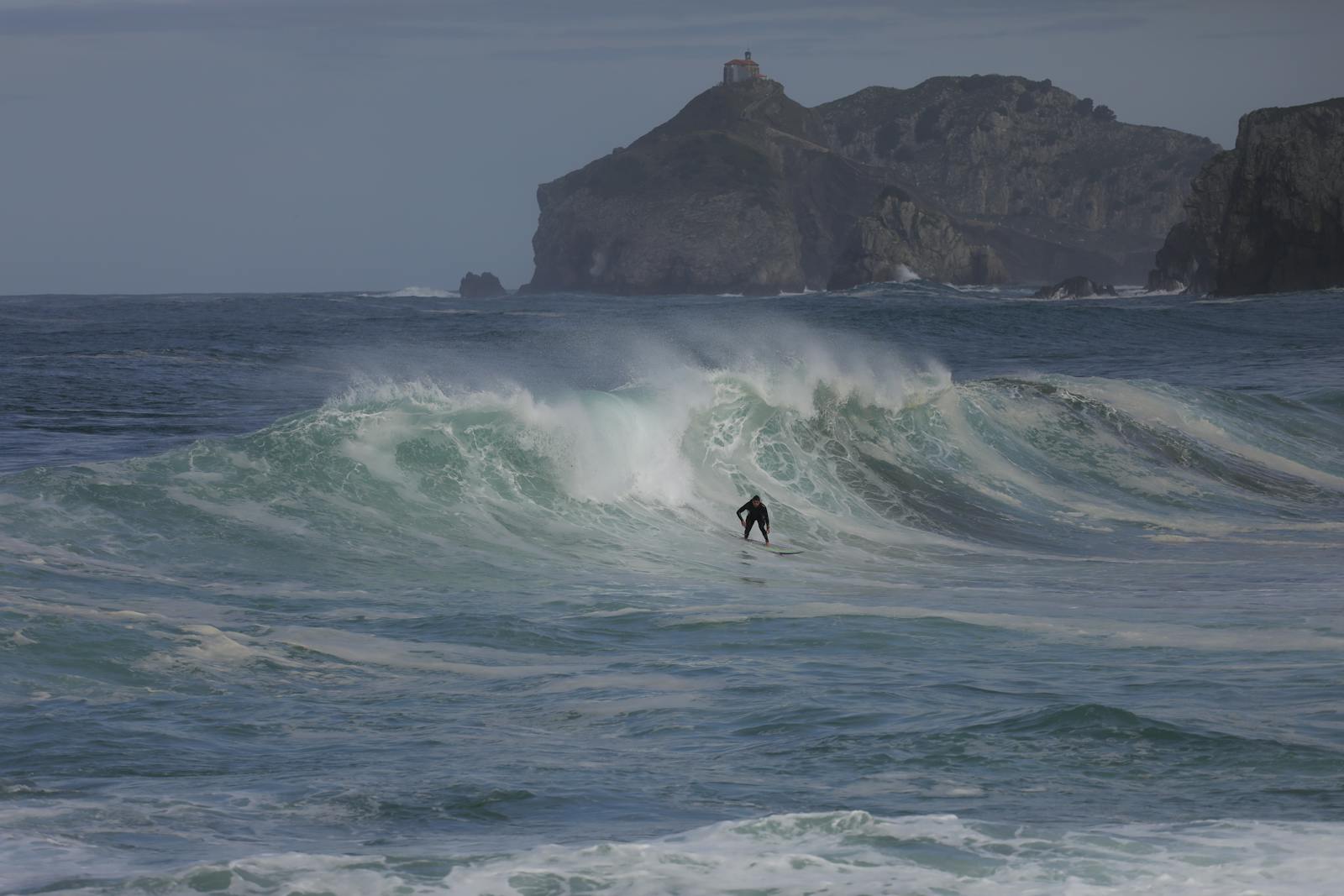 ALT: Surfeur à Bakio au Pays Basque, illustration d’une saisonnalité forte et d’afflux de visiteurs