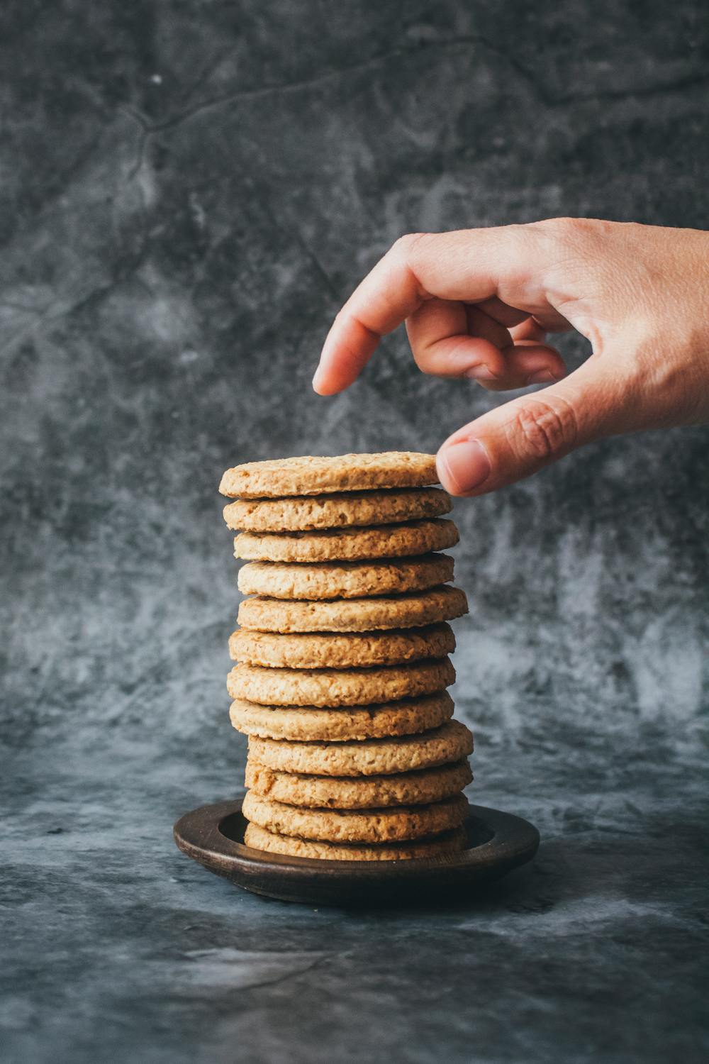 stack of cookies. person reaching for the one on top