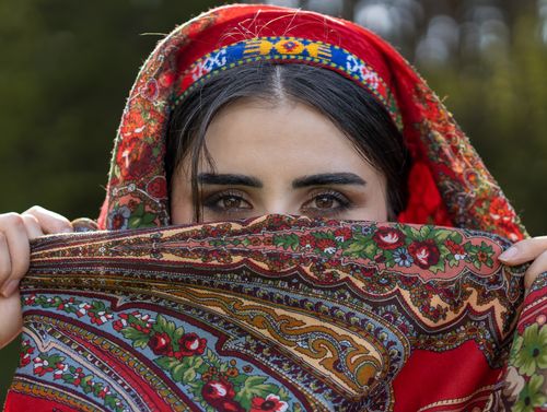 Free Close-up portrait of woman with colorful scarf and intricate design, outdoors. Stock Photo