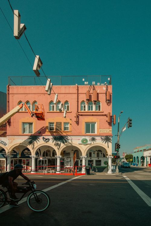 Free Vibrant street view of Venice Beach with iconic architecture and a cyclist in Los Angeles, California. Stock Photo