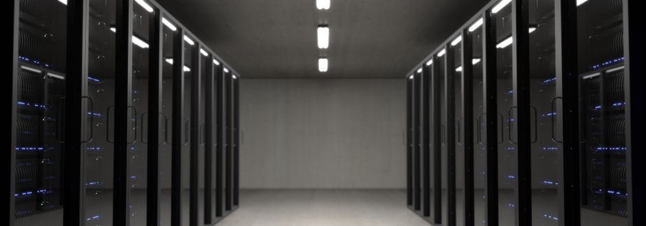 Long corridor of lit server racks inside an operating turnkey data hall