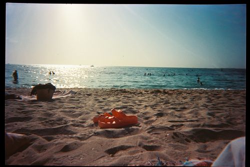 Free A serene beach scene in Dubai with people enjoying the ocean under a clear sky. Stock Photo