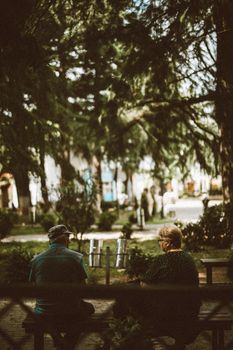 Elderly couple enjoying a peaceful afternoon in a lush park in Kutaisi, Georgia.