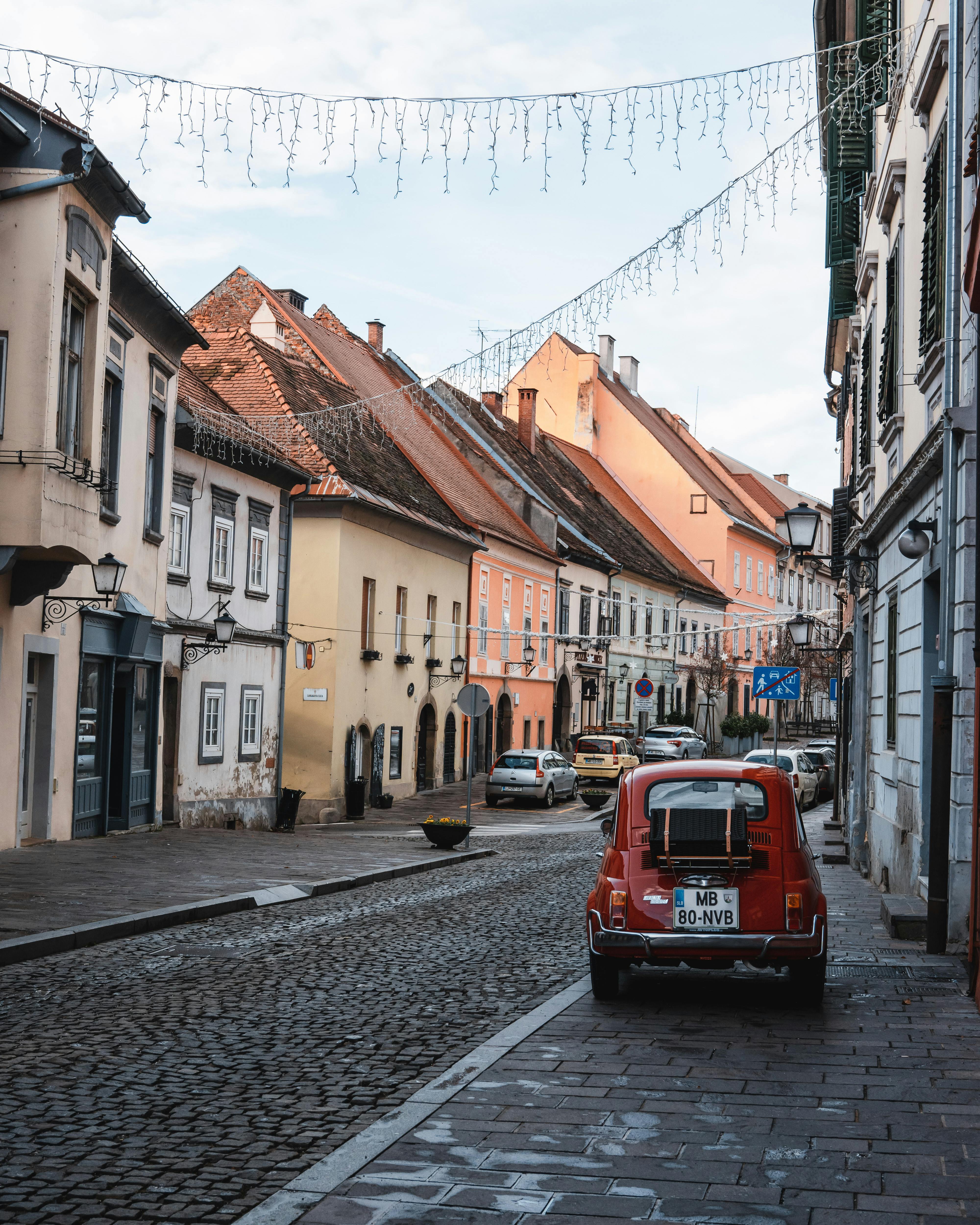Picturesque European street scene with vintage car, capturing historic charm and vibrant architecture.
