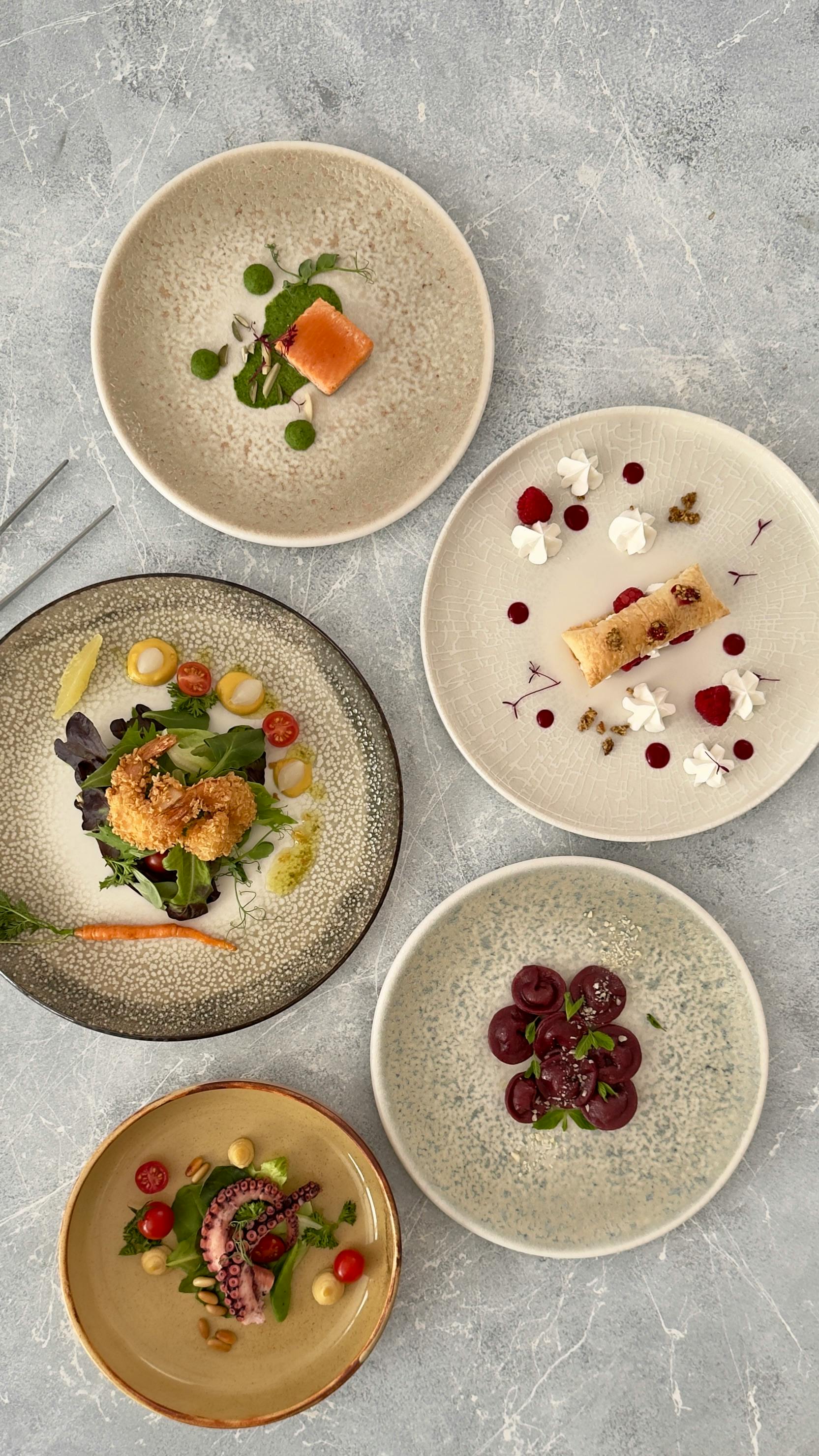 Elegant display of gourmet dishes artfully arranged on a marble table.