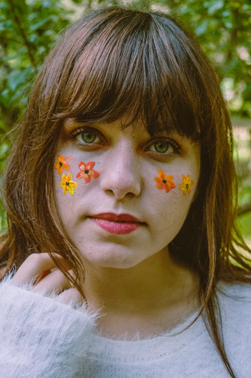 Крупным планом фото женщины с цветочной краской для лица