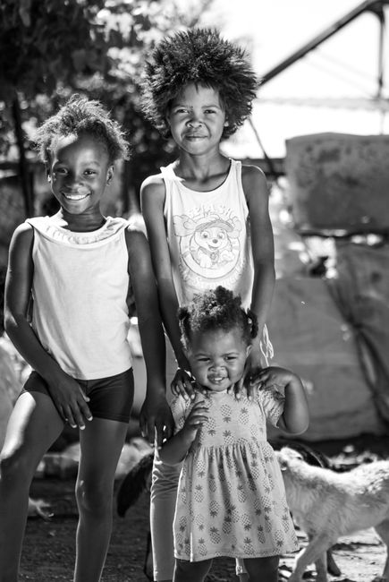 Fotomural Fotografía en blanco y negro de tres niños felices disfrutando de un día soleado al aire libre.