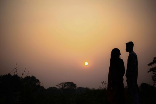 Silhouette of a couple during a romantic sunset, depicting love and serenity.
