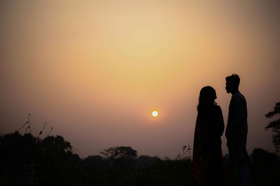 Silhouette of a couple during a romantic sunset, depicting love and serenity.
