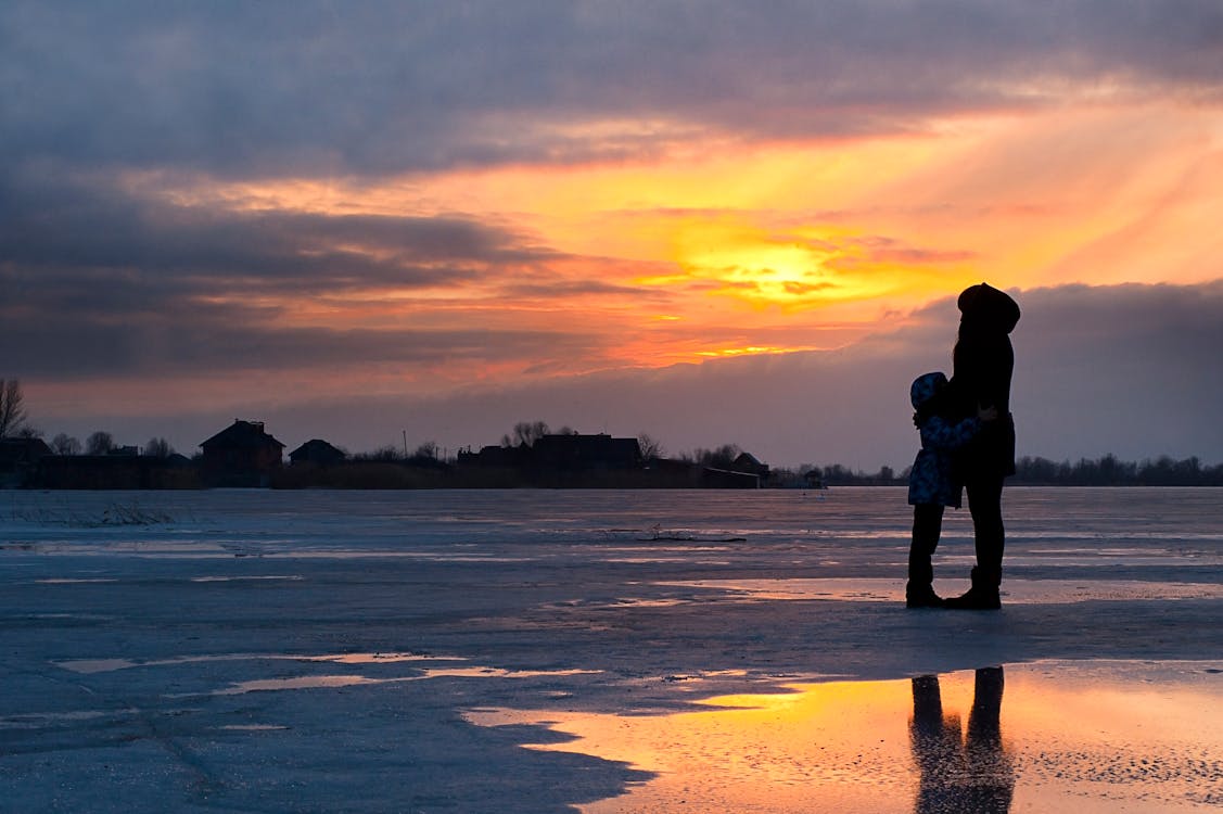 Child and Woman Standing Near Water