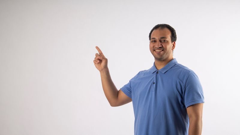 A person pointing to the energy guide sticker on the side of a window air conditioner