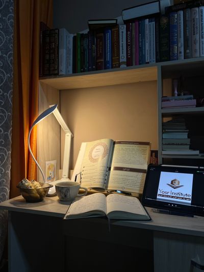 Open book beside a warm lamp at night — photo by Baku Kerimbekova on Pexels