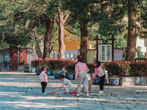 Free Children enjoy a sunny day in a park, playing with brooms among lush greenery. Stock Photo