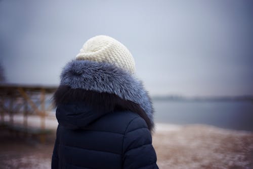 Femme Portant Une Veste Parka Bleue Et Une Casquette En Tricot Blanc