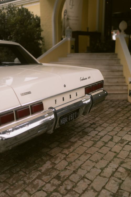 Free Classic Ford Galaxie 500 car parked by historic building entrance. Stock Photo
