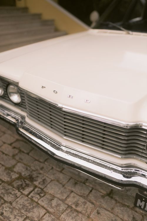 Free Detailed view of a vintage white car's grille and headlight, showcasing classic design. Stock Photo