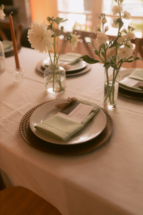 Free Charming dinner table setup with elegant flowers and soft lighting, perfect for intimate gatherings. Stock Photo
