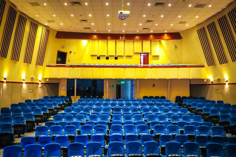 Wide-angle view of a vibrant auditorium with blue seats