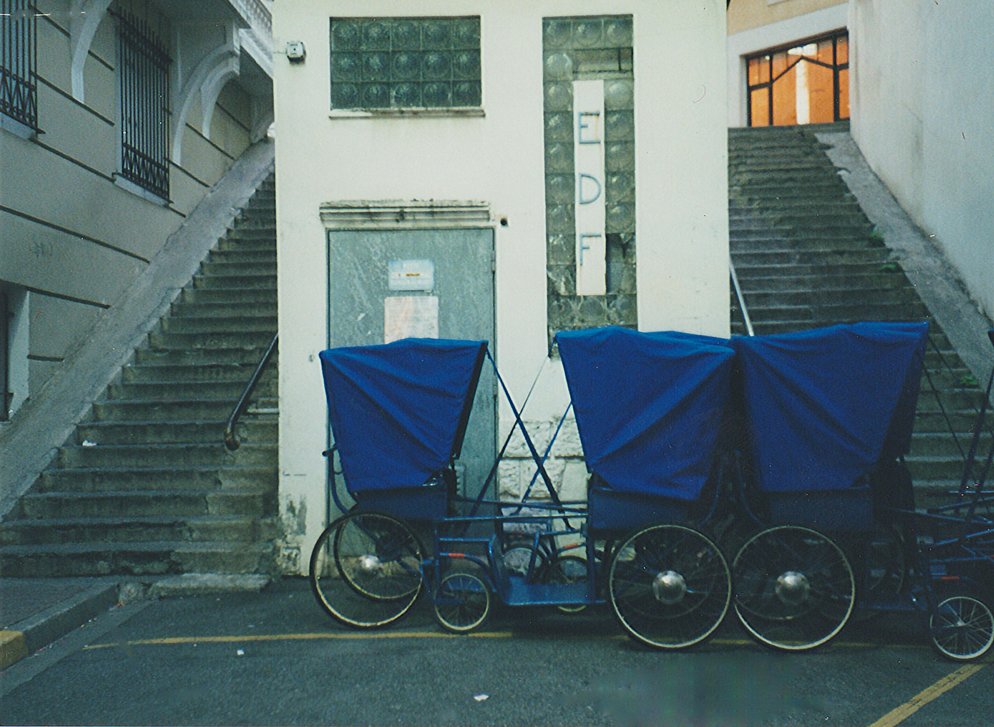 Gratis I vecchi risciò blu parcheggiati vicino alle scale di Lourdes, in Francia, evocano un fascino storico. Foto a disposizione