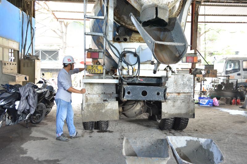 Worker beside a concrete mixer chute