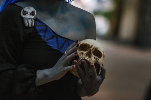 A unique cosplay with blue accents holding a skull, shot in Ciudad de México.