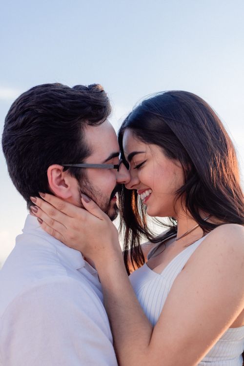 Free Couple sharing a loving embrace outdoors, bathed in warm sunlight, capturing a moment of happiness. Stock Photo