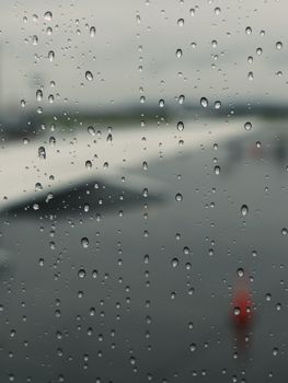 Raindrops on a window looking over an airport tarmac in Mississauga, Ontario on a rainy day.