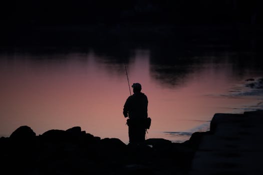 A lone fisherman casting a line at sunrise in Cove Island Park, Stamford, Connecticut.