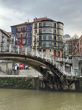Vibrant buildings and bridge over the Bilbao river showcasing urban charm.