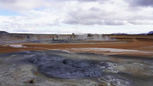 Free Scenic view of steaming geothermal area in Myvatn, Iceland with tourists exploring. Stock Photo