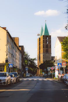 Street view in Kassel, featuring historic buildings and a church tower during golden hour.