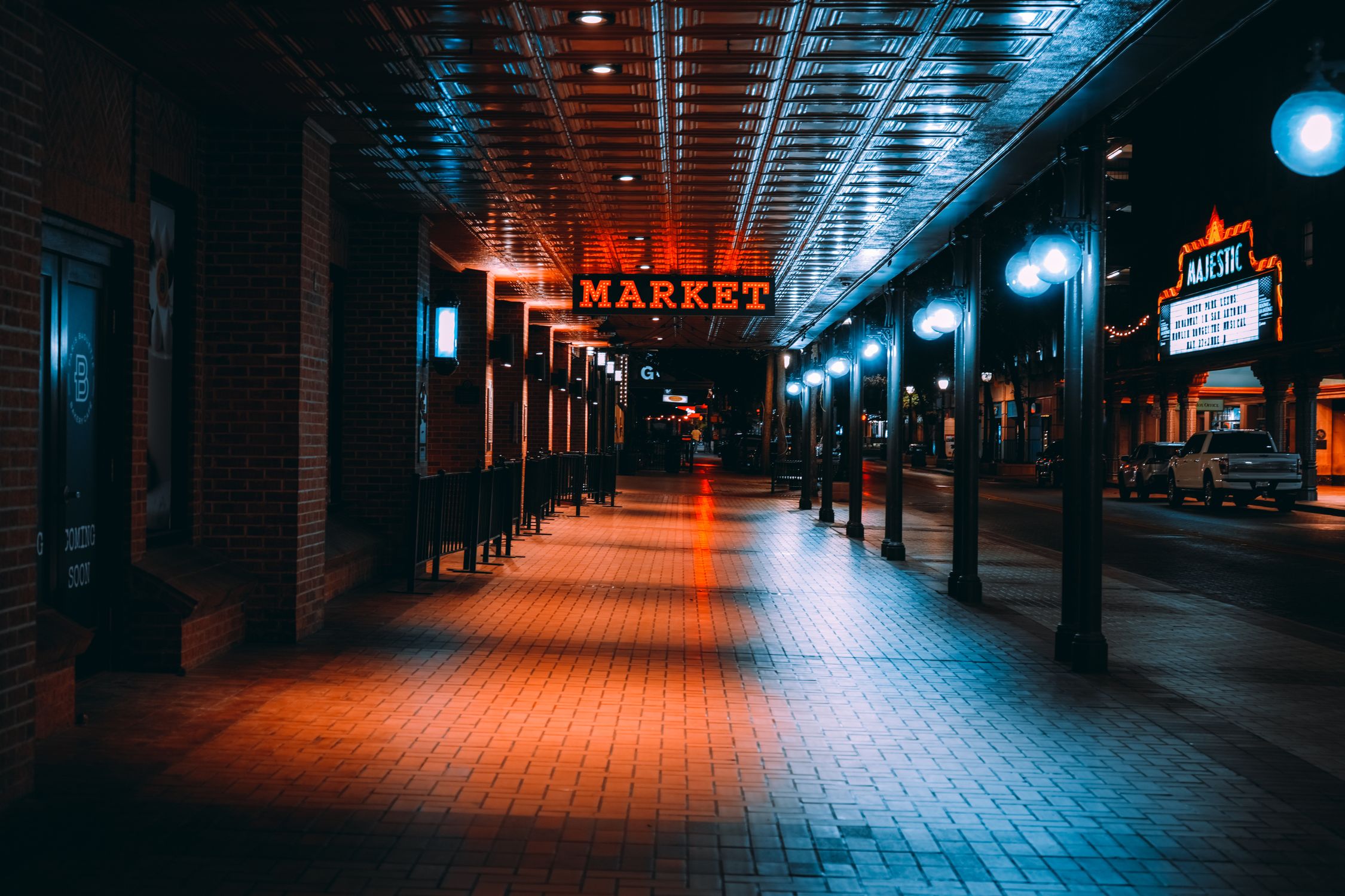 Colorful night view of San Antonio Market with bright lights and reflections.