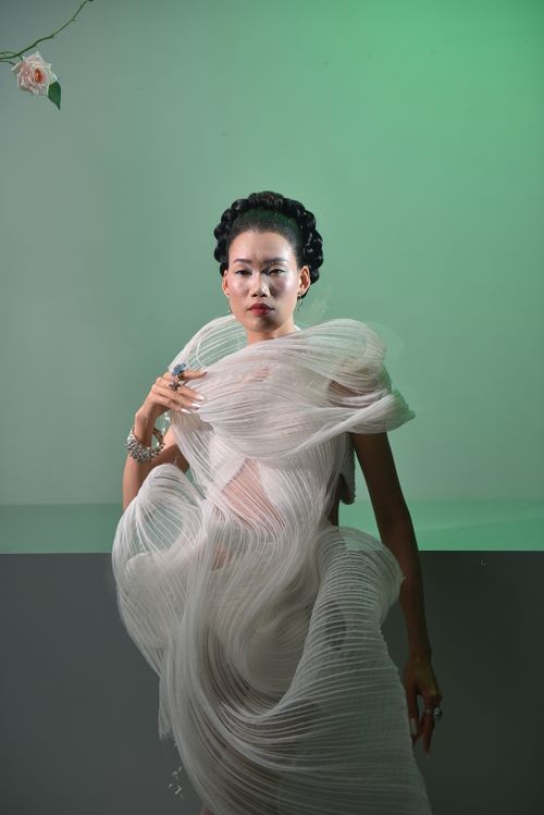 Free Stylish portrait of an elegant woman in a flowing modern dress with green lighting. Stock Photo