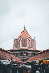 Historic building surrounded by market stalls in Pune
