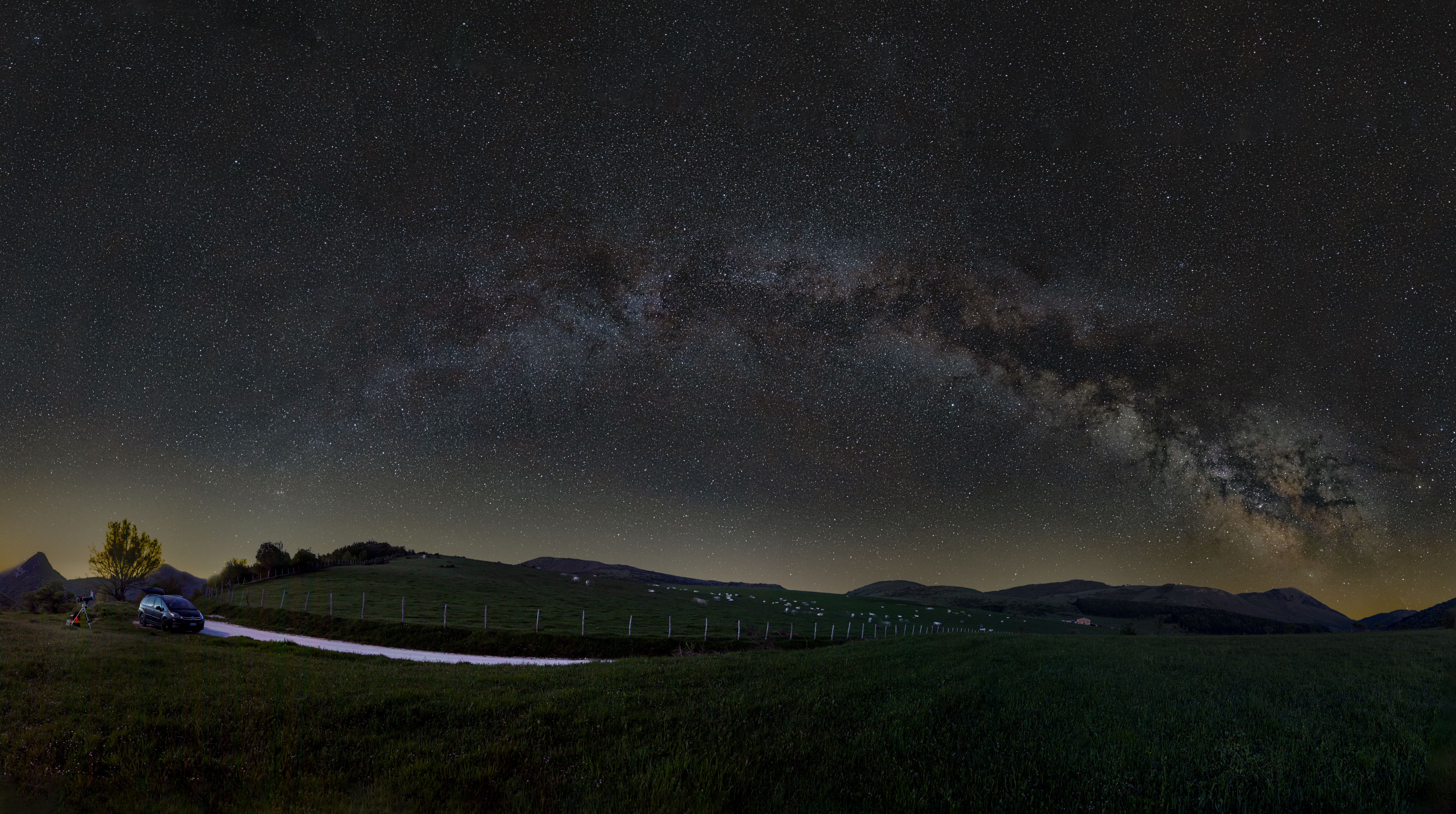 Stunning Milky Way arch over fields in Sefro, Marche, Italy. Starry night landscape.