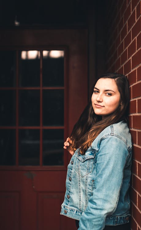 Free Woman Leaning on Concrete Brick Wall Stock Photo