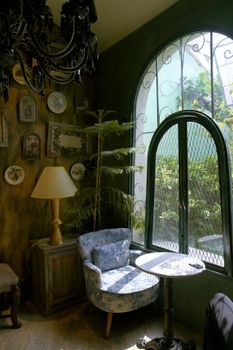A charming vintage room corner with a comfy armchair, wall decor, and natural light.